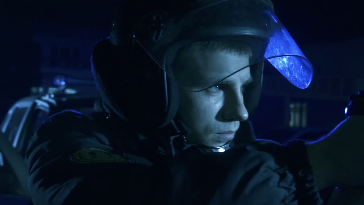 oficial de policía con un arma en el fondo de parpadeantes intermitentes