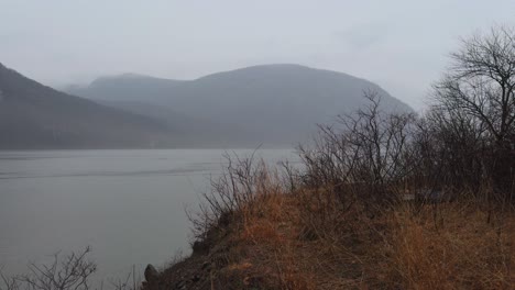 a beautiful, mysterious foggy and rainy day during autumn on the hudson river in new york, with the appalachian mountains in the background