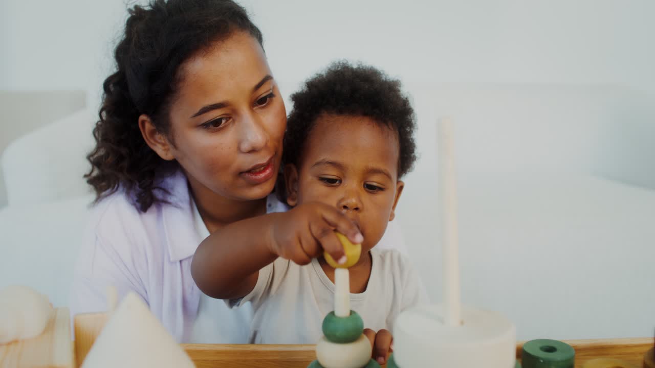 madre e hijo jugando con anillos de madera