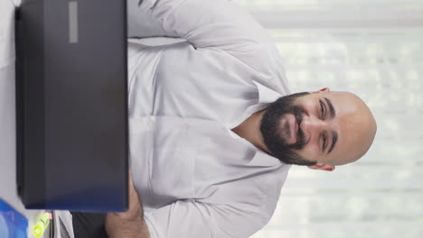 Vertical-video-of-Home-office-worker-man-looking-smugly-at-camera.