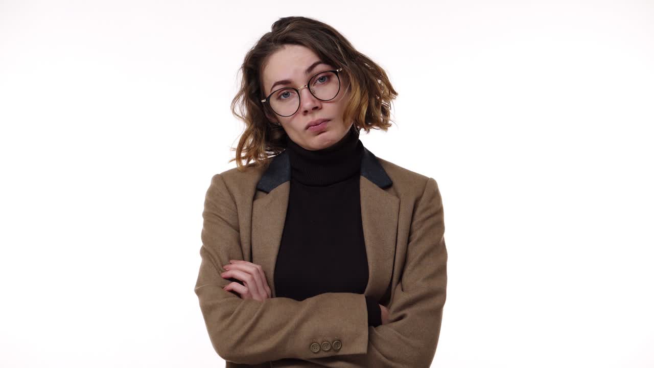 Portrait of and attractive brunette woman in glasses and stylish jacket irritated with waiting, yelling and gesturing with