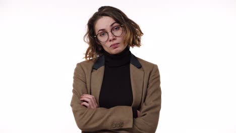 retrato de una atractiva mujer morena con gafas y chaqueta elegante irritada con la espera, gritando y gesticulando con