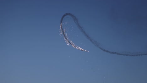 tracking shot of a pyrotechnic aircraft letting off fireworks during its display