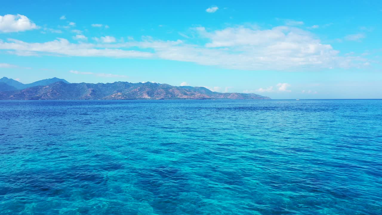 Mountains in the ocean background, Bright blue sky over the mountains on the tropical island with fluffy clouds,