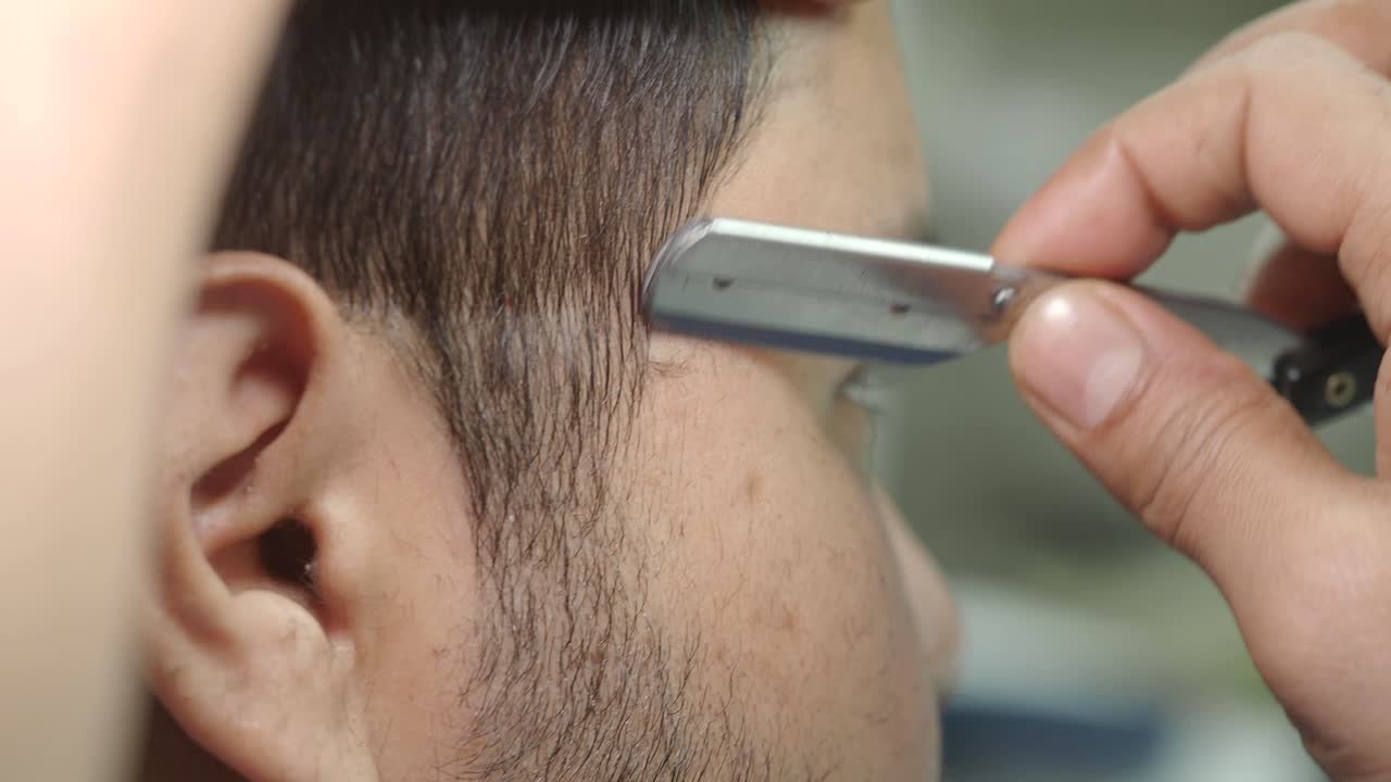 Close-up of Men's Grooming with Straight Razor and Comb at Barbershop