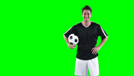 Fußballspieler-Hält-Einen-Fußball-Vor-Grünem-Bildschirm