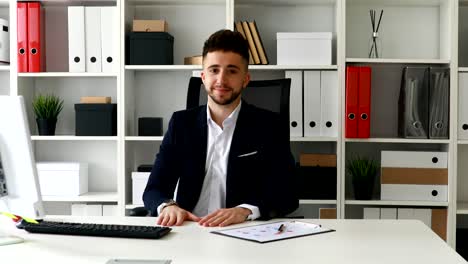 young businessman making gesture okay and looking at camera