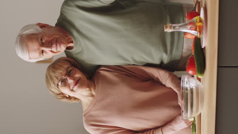 Romantisches-älteres-Paar,-Das-In-Der-Küche-Kocht-Und-In-Die-Kamera-Lächelt