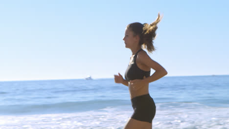 fit woman jogging in the beach 4k