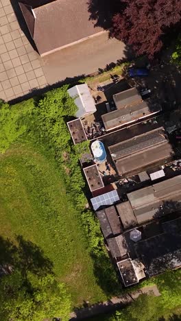 aerial view of a diverse urban landscape with mobile homes, green spaces, parking lot, and building