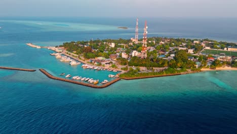 a stunning aerial drone view showcasing rasdhoo island surrounded by crystal-clear turquoise waters and vibrant coral reefs in the maldives.