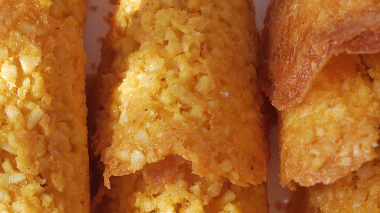 Detailed pan right of crispy almond Tejas sweets under direct sunlight, revealing texture and color