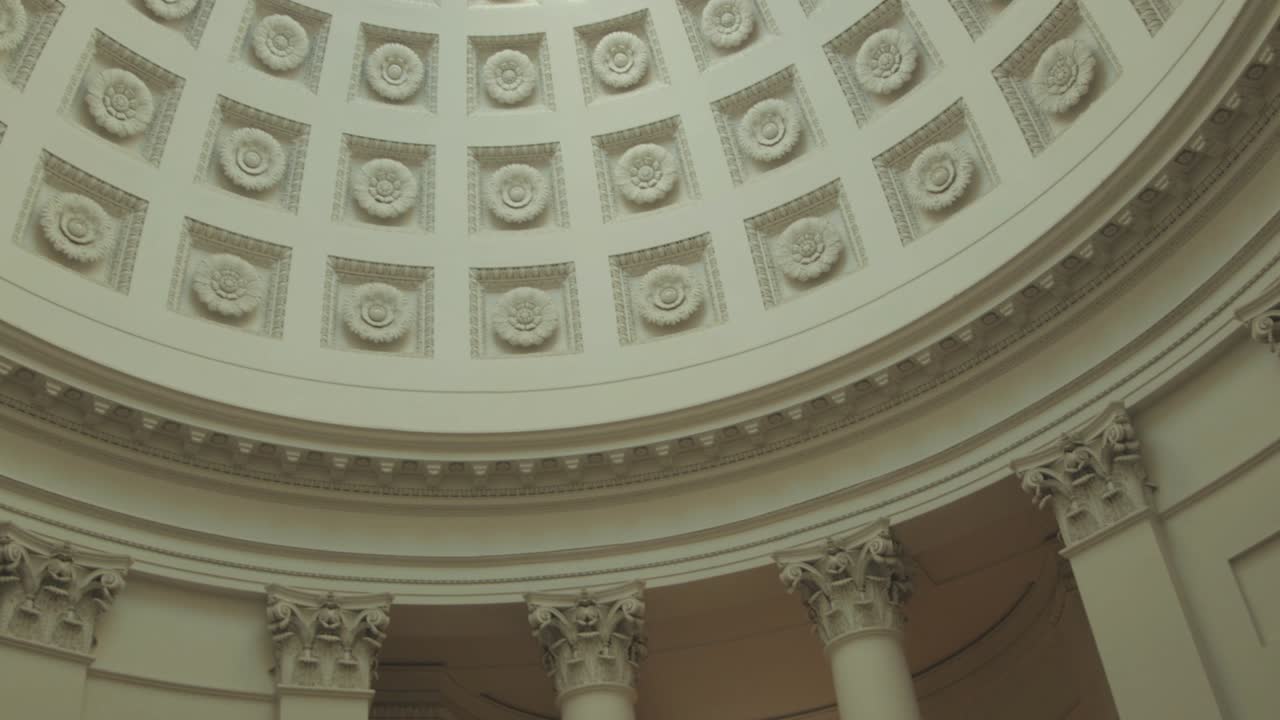 pan shot of a round dome, sun shines through a small window on the ceiling, and illuminates an old architecture, in the sun, at Grabkapelle Stuttgart, Baden Württenberg, in Germany