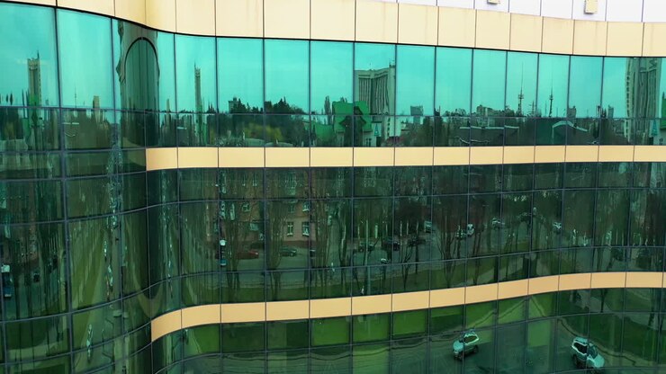 Facciata di un moderno edificio in vetro. Superficie di un edificio in vetro con il riflesso della città.