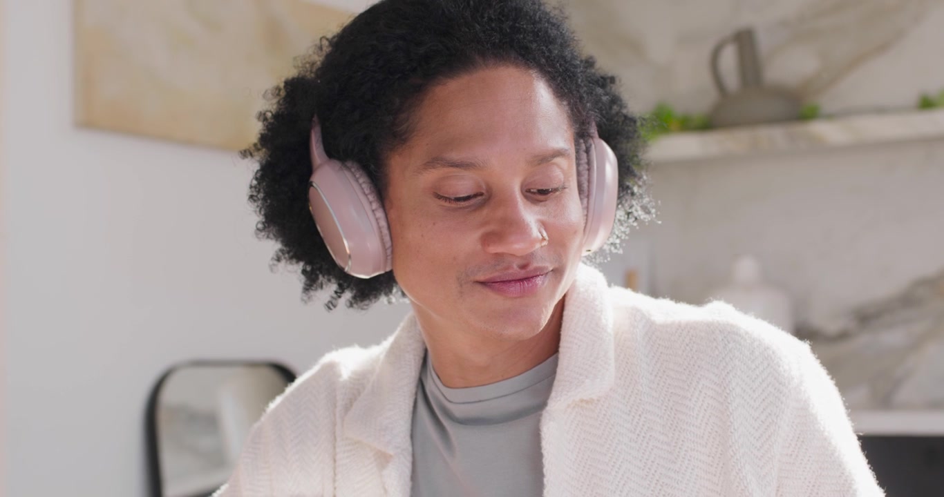 African American man placing hands on laptop typing with stylus for work listening on pink headset