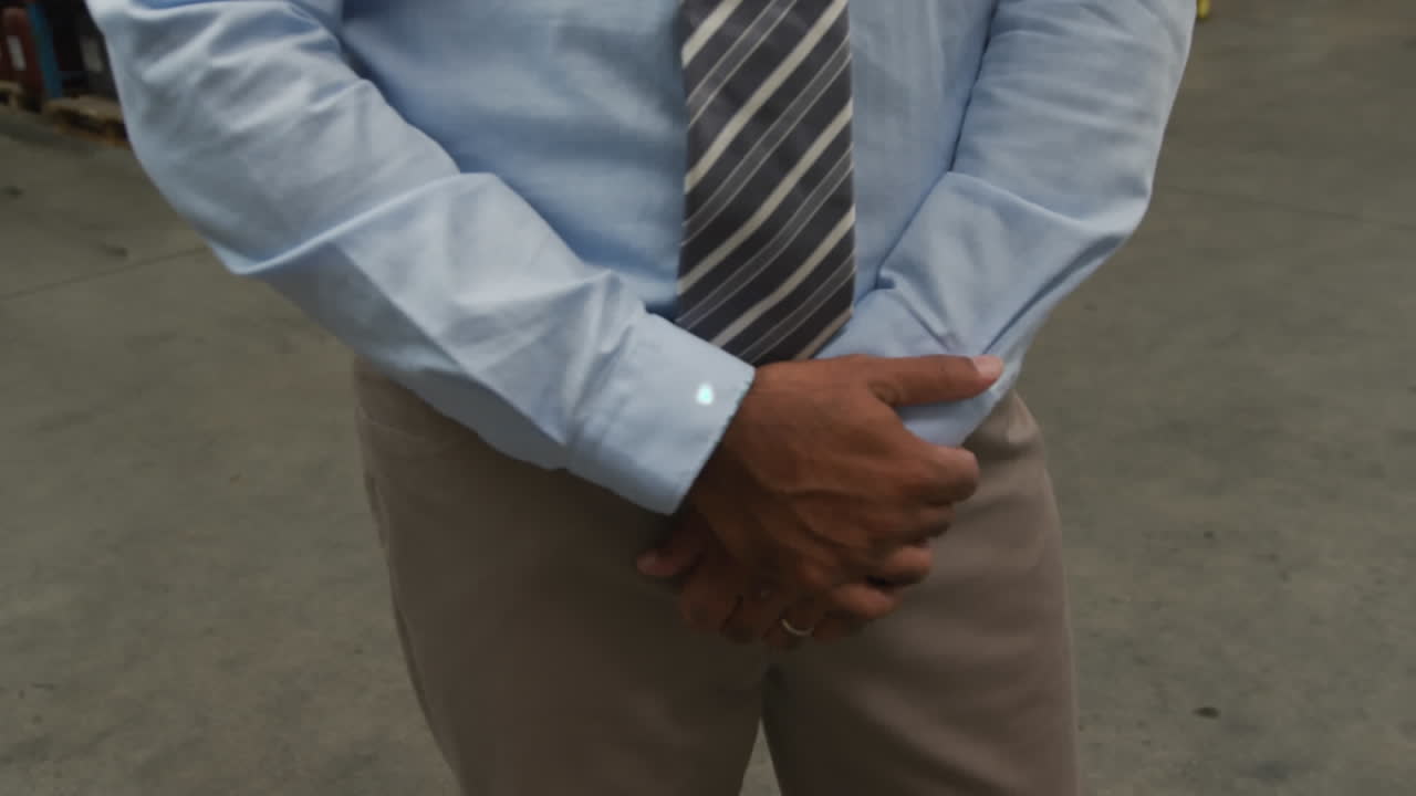 animación de una red de iconos digitales contra un supervisor caucásico sonriendo en el almacén.