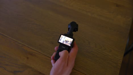 Close-up-on-active-lit-screen-of-DJI-Osmo-Pocket-3-stabilized-handheld-mobile-camera-while-filming