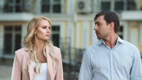 Closeup-couple-walking-together-at-street.-Business-partners-discussing-work