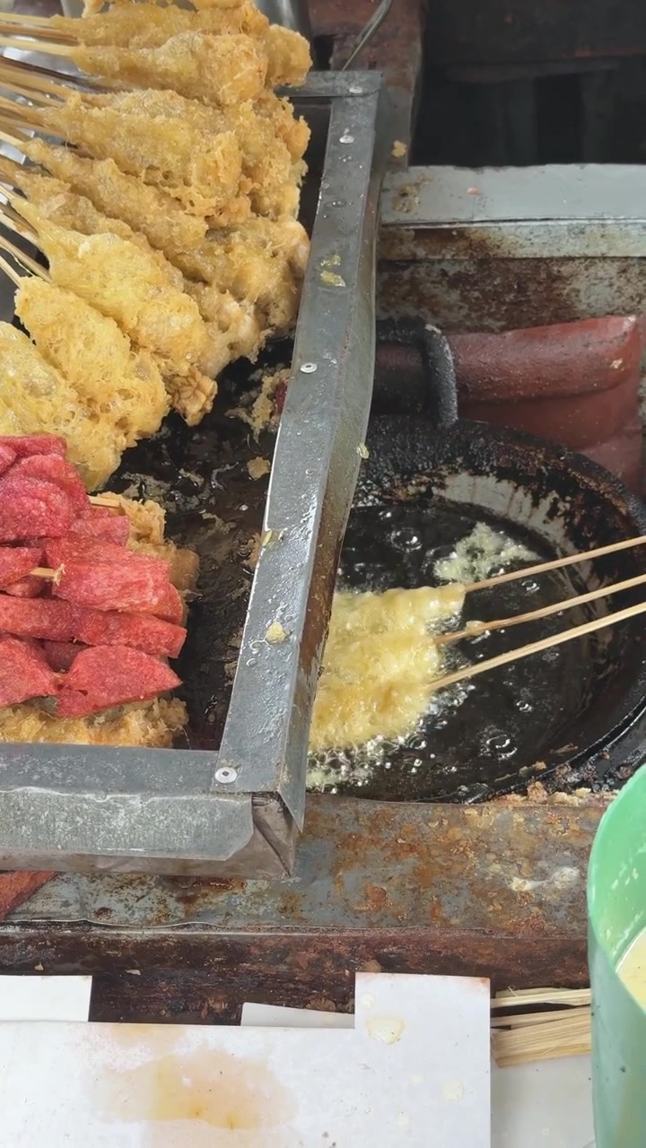 Pedagang Kaki Lima Menggoreng Sate Telur dalam Minyak Panas