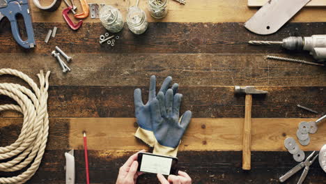 top view artisan craftsman hands using smartphone touchscreen viewing building plans from above - red epic dragon