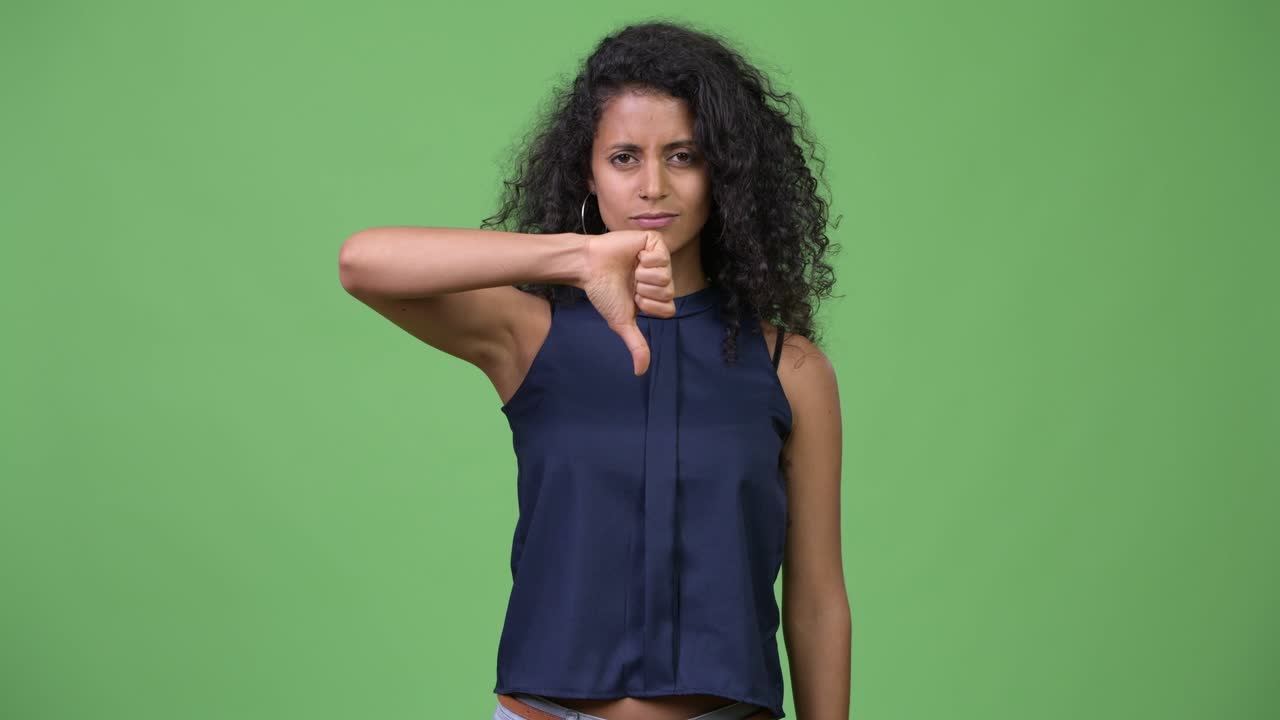 Young beautiful Hispanic businesswoman giving thumbs down