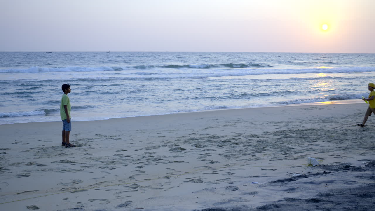 해변에서 프리스비를 치는 소년들