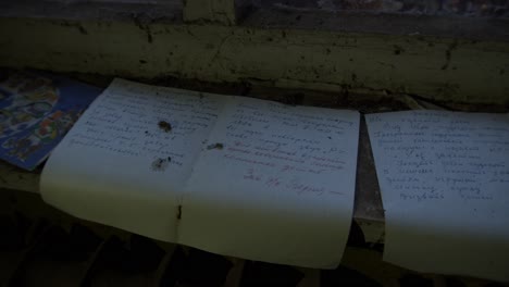 torn notebook pages with hand writing - chernobyl disaster - pripyat, ukraine - handheld shot