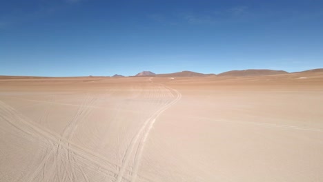 Dramatic drone shot over sand dunes with bold shadows cast in late afternoon Bolivia light