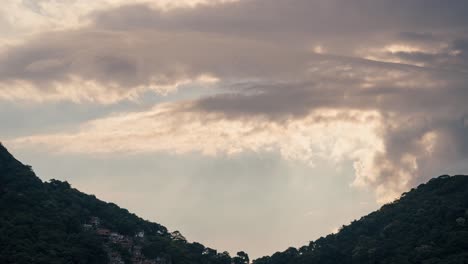 time lapse of storm cloud formations passing by mountains, sun rays shining through