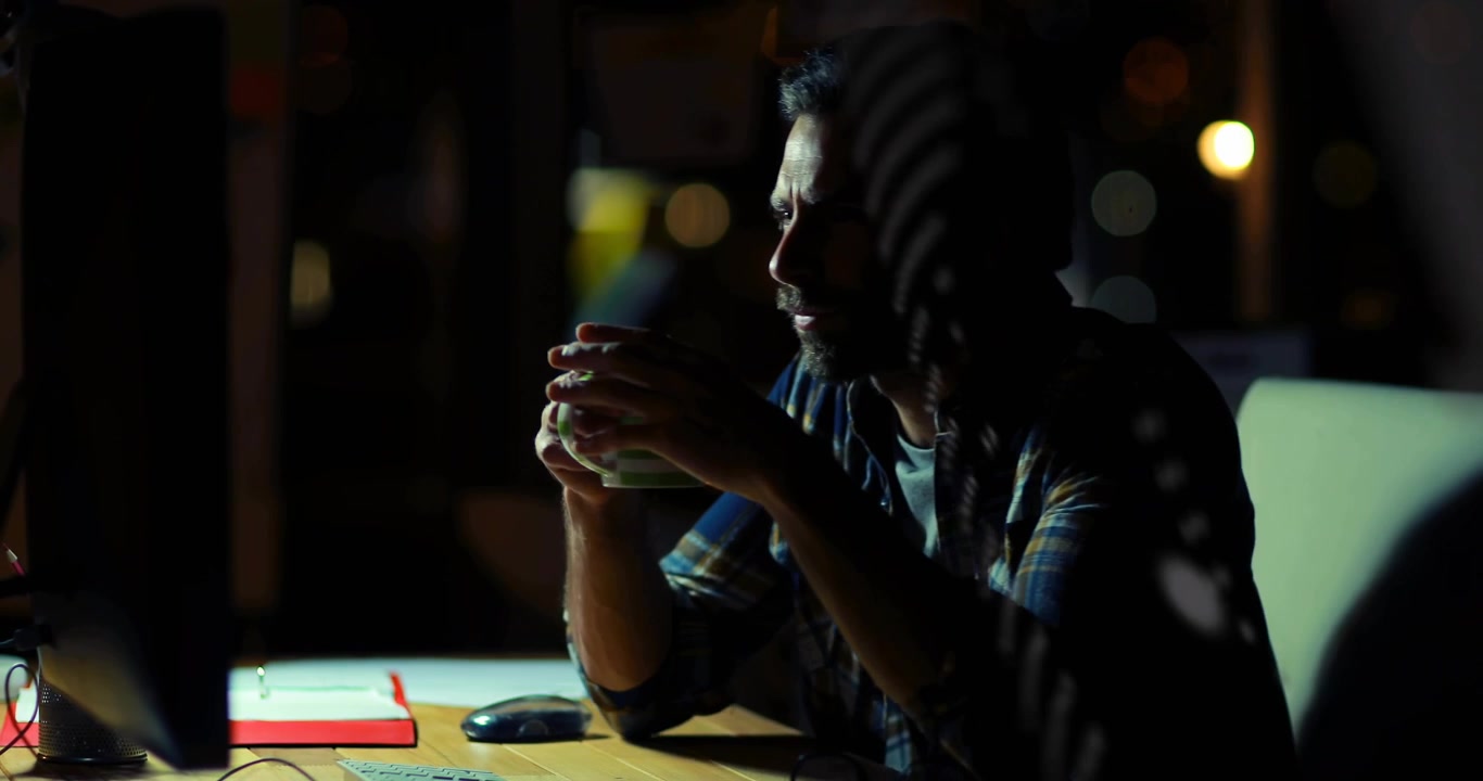 Developer typing and sipping coffee while binary code overlay lighting nighttime desk during coding
