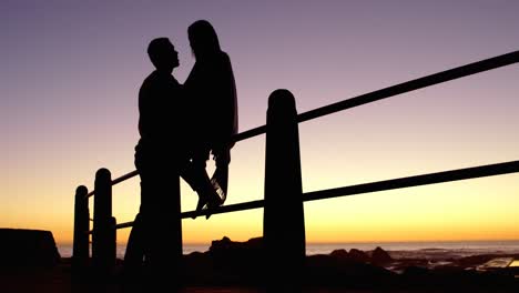 Silhouette-of-couple--romancing-near-railings-4k