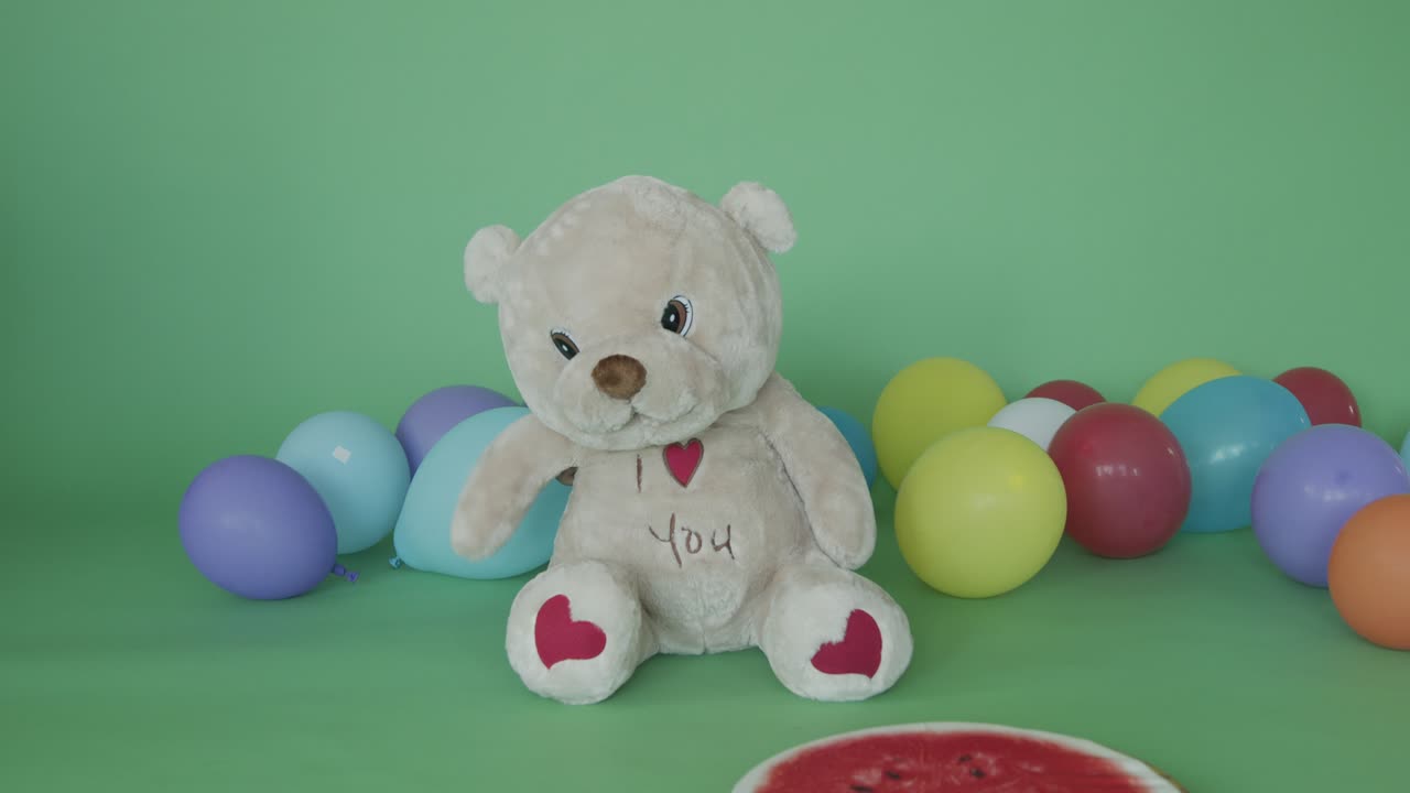 A teddy bear among balloons