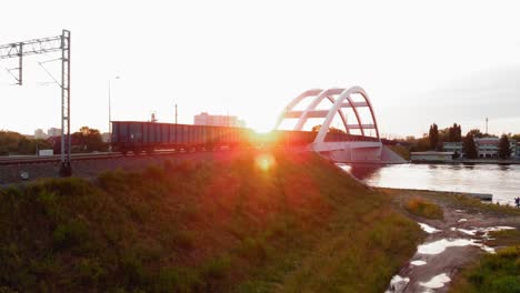 Tren-Con-Contenedores-De-Carga-Moviéndose-Hacia-Abajo-En-El-Puente-Ferroviario