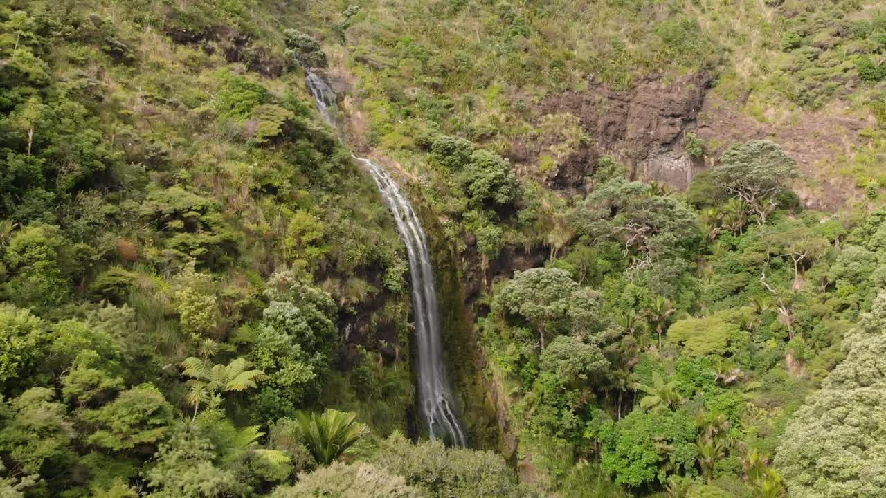 volando hacia las hermosas cataratas de kitekite en la naturaleza nativa de nueva zelanda