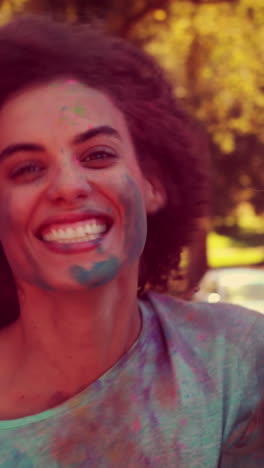 amigos felices cubiertos de pintura en polvo sonriendo a la cámara