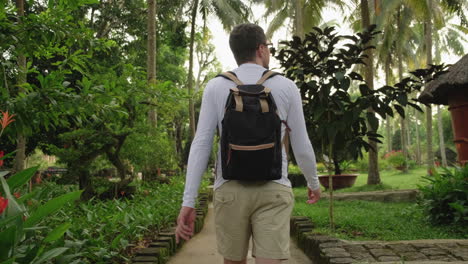 man hiking through a tropical garden