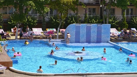 gelukkige kinderen en volwassenen zwemmen in het zwembad tijdens de vakantie.