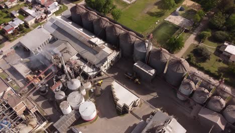 aerial top down shot of fumes rising up of chimney from food factory in suburb of buenos aires during sunny day