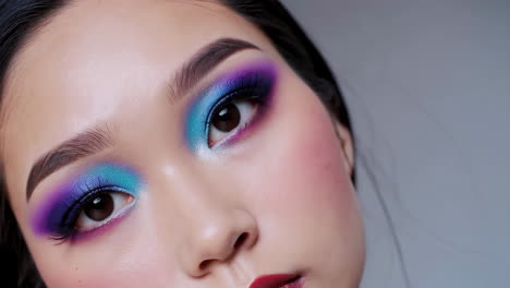 close-up portrait of a woman with vibrant artistic makeup