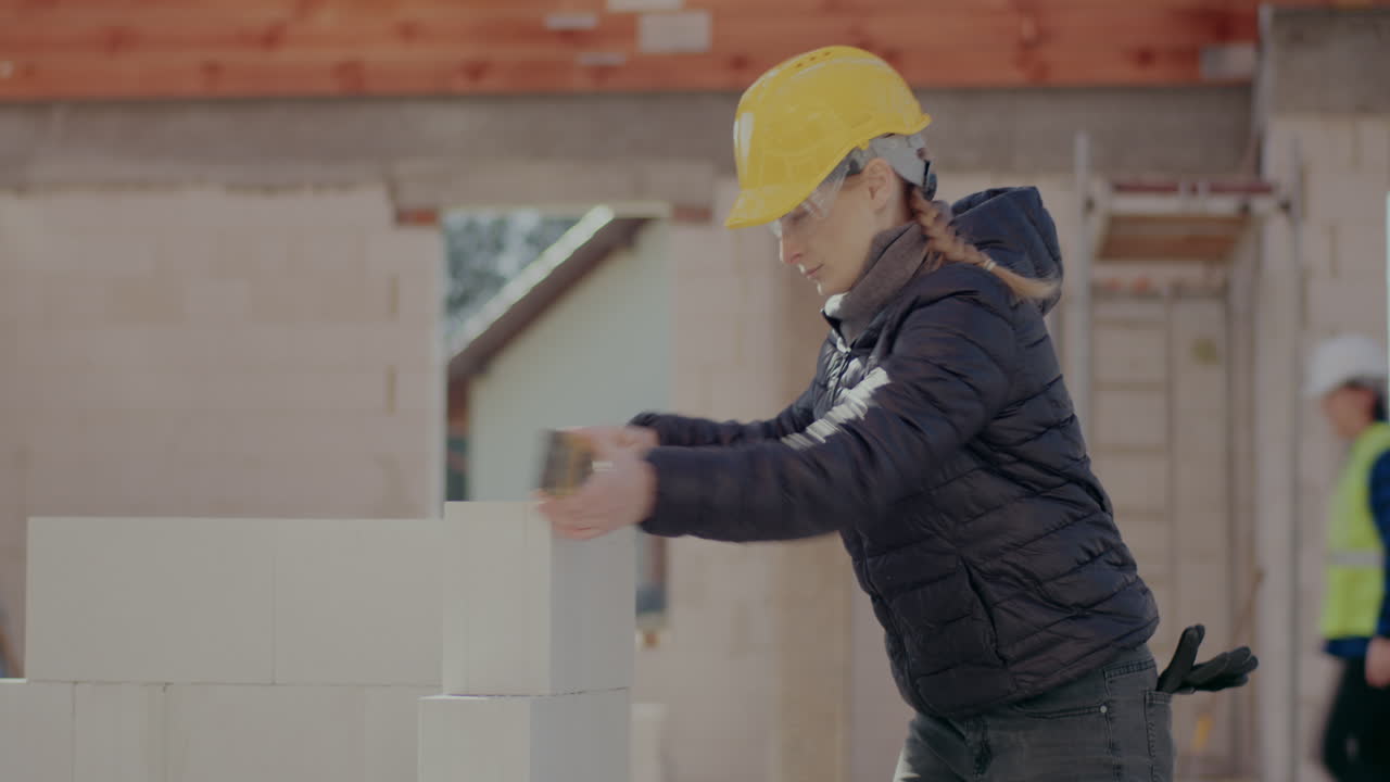 Lockdown shot of confident young female supervisor analyzing concrete wall with level at construction site