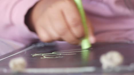 child drawing on a chalkboard tablet