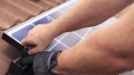 Closeup-of-PV-professional-hands-installing-Solar-Panel-on-roof-house,-day