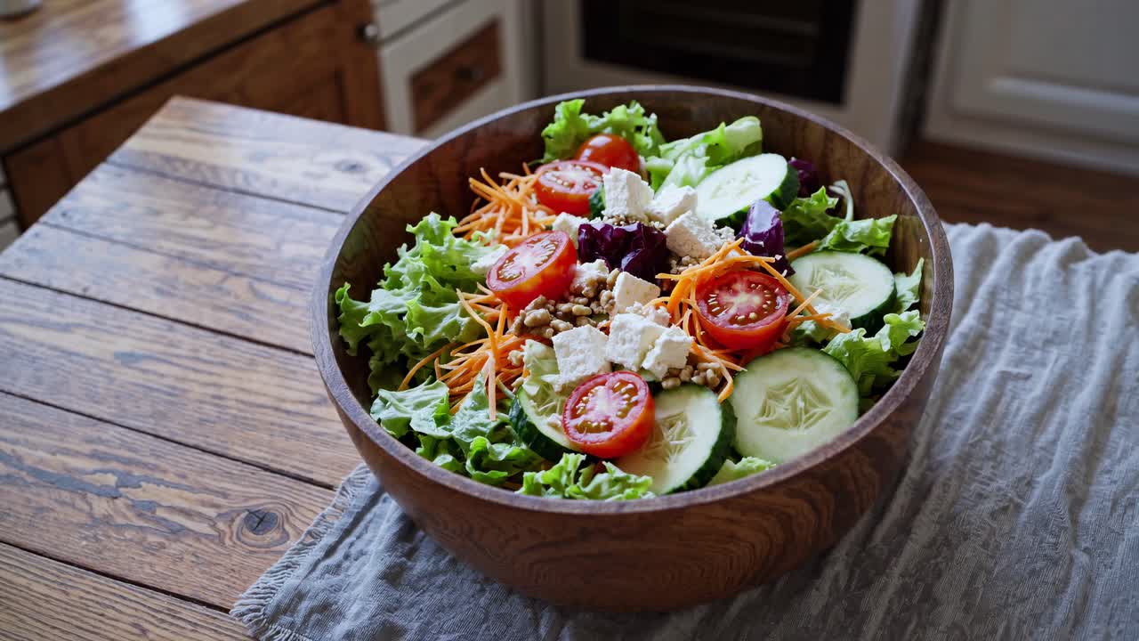 A rustic kitchen video still of a fresh salad in a wooden bowl