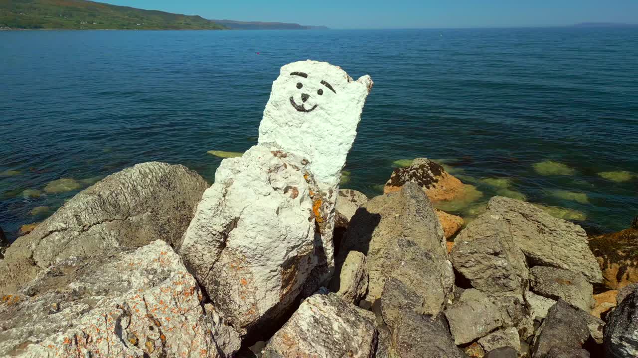 Reversing aerial video of the Ballygally polar bear on the Antrim Coastal Route on a bright and sunny day. Filmed in Ballygally in 4K, 60FPS and with Rec800 color.