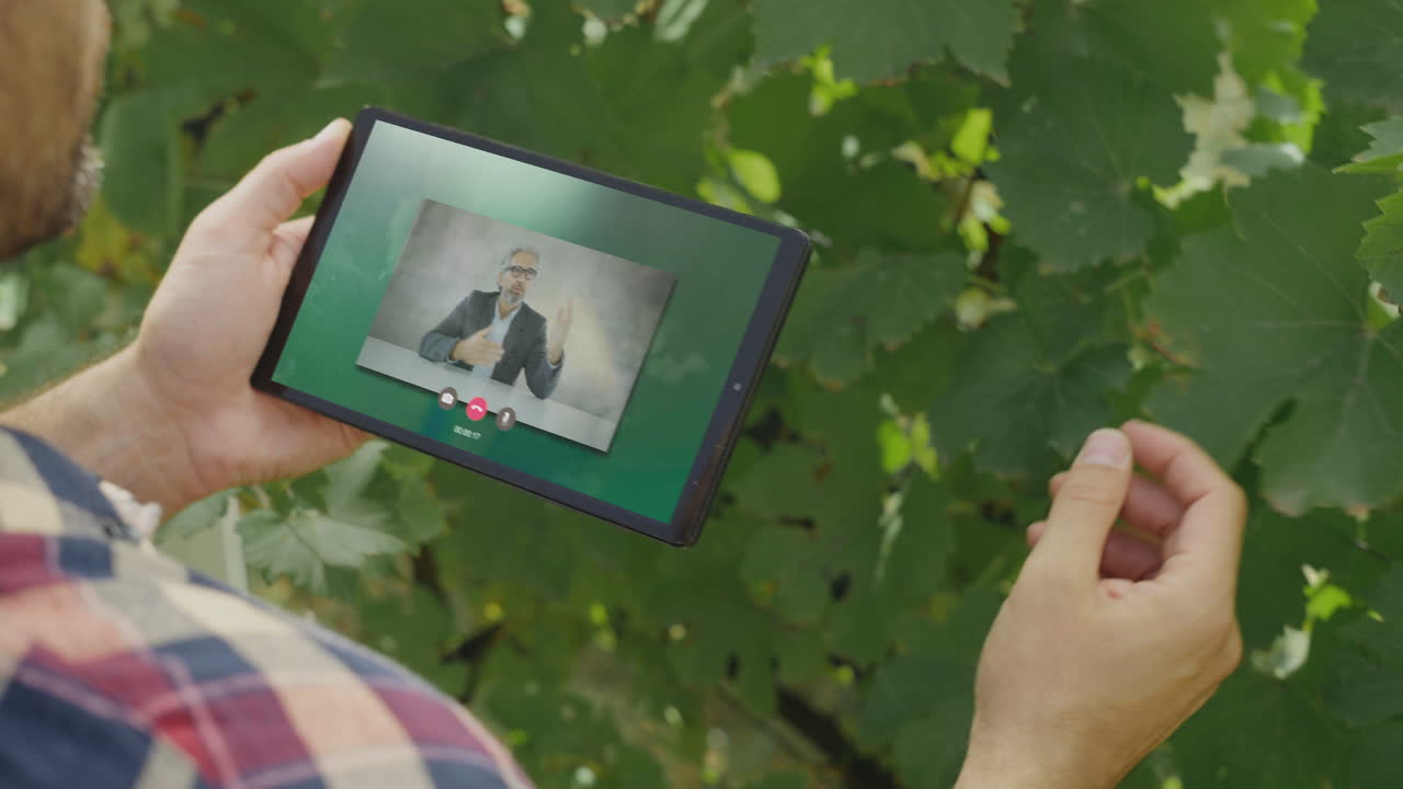 Farmer Consults with Agricultural Expert via Video Call in Vineyard