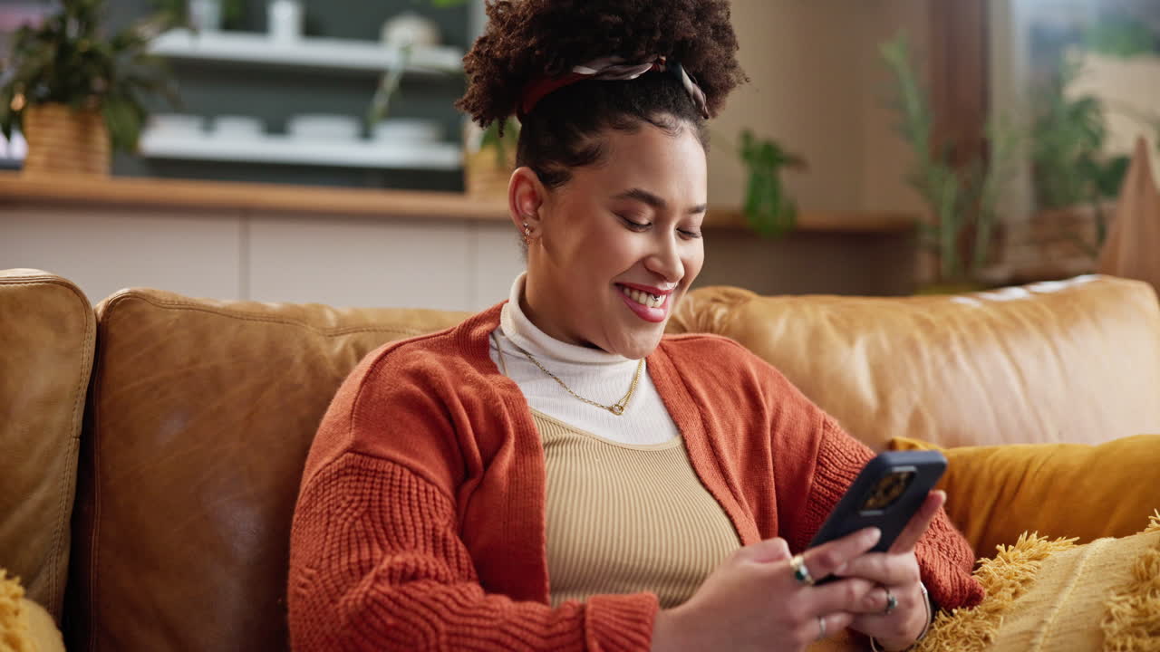 Woman sitting on a couch and using her phone