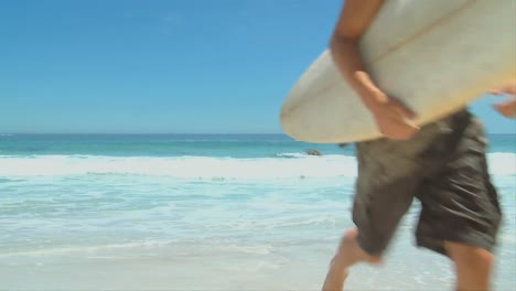 Man-with-surf-board-coming-out-of-the-water-
