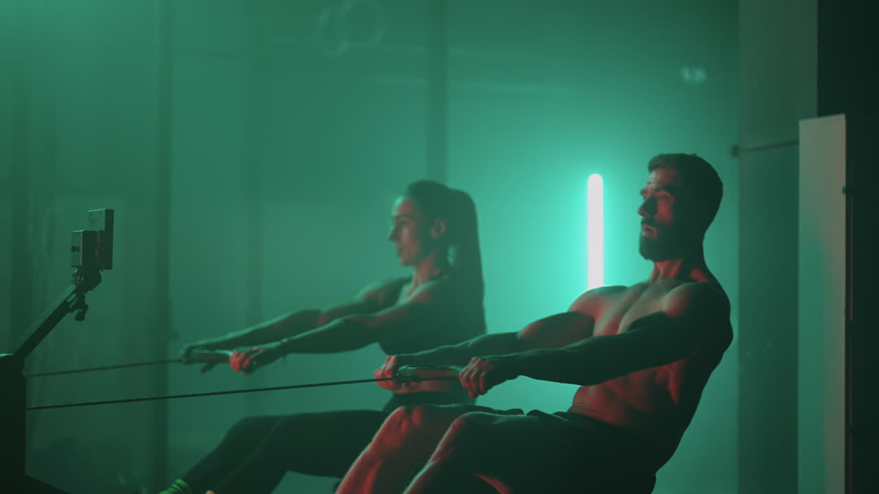 크로스피트 체육관 의 훈련 시 ⁇ 레이터 에서 근육적 인 남자 와 운동적 인 여자 의 운동. 근육적 인 스포츠 남자 와 여성 의 운동 시 ⁇ 레이터 에서 체육관 에서 운동 하는 여자 선수 들