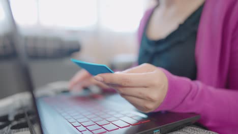 a close-up woman sitting on a sofa holding a smartphone for shopping online at home