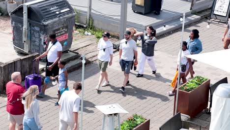 pedestrians stroll along a sunny street